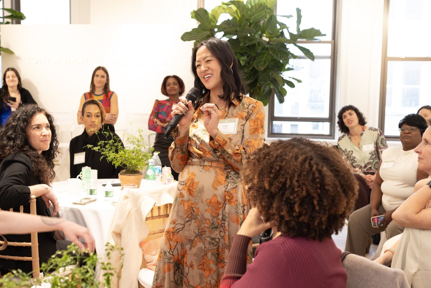 Judy Tsuei speaking with a microphone to a seated group of founders